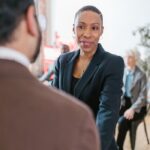 Businesswoman engaging in a professional handshake during a meeting, promoting teamwork.